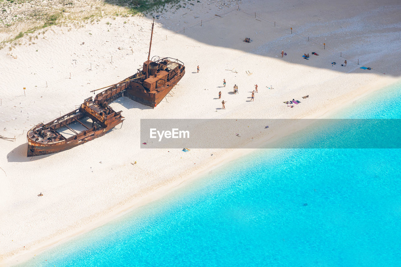 High angle view of shipwreck and people at beach