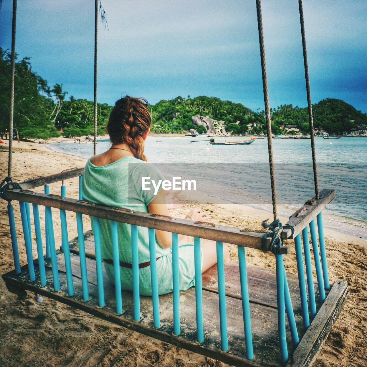 Rear view of woman sitting on pier