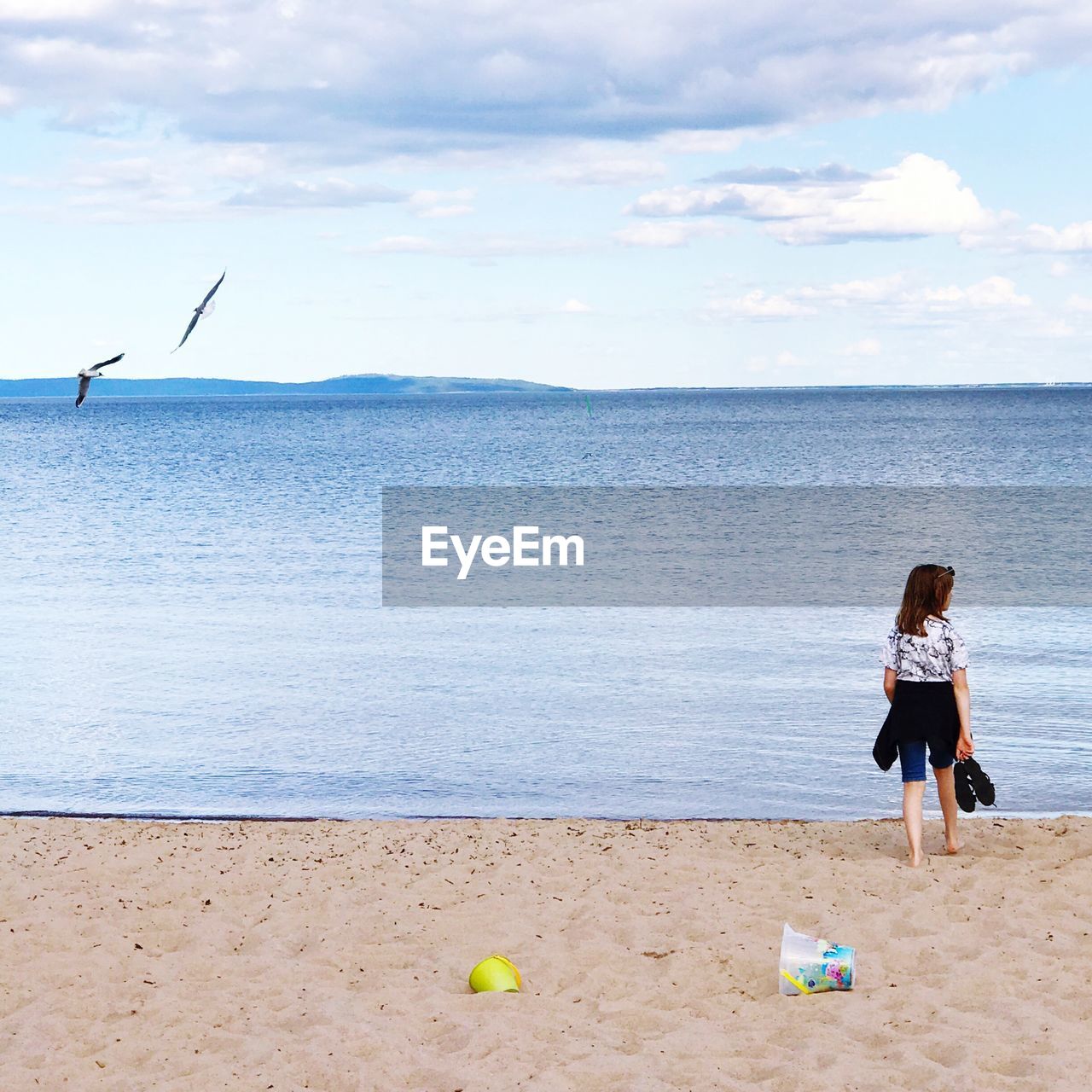 Rear view full length of girl walking on shore at beach