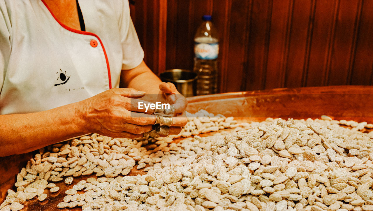 MIDSECTION OF MAN PREPARING FOOD AT KITCHEN