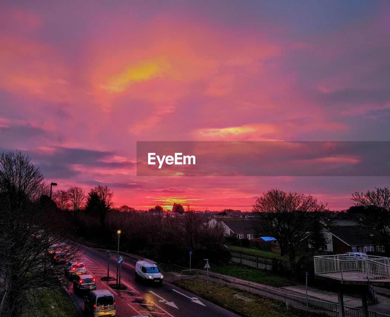 High angle view of cars on street against cloudy sky at sunset