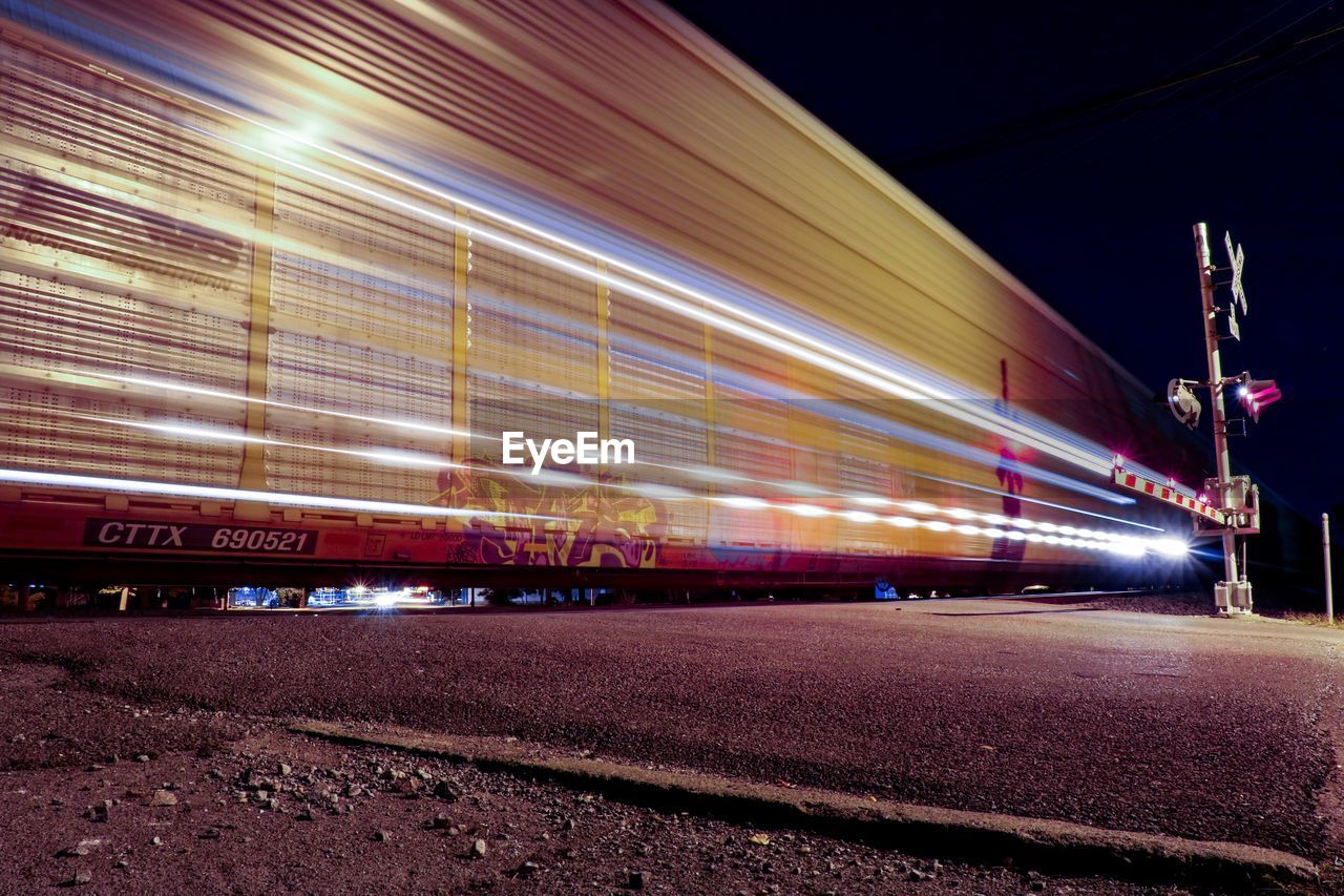 LIGHT TRAILS ON ILLUMINATED BRIDGE AT NIGHT