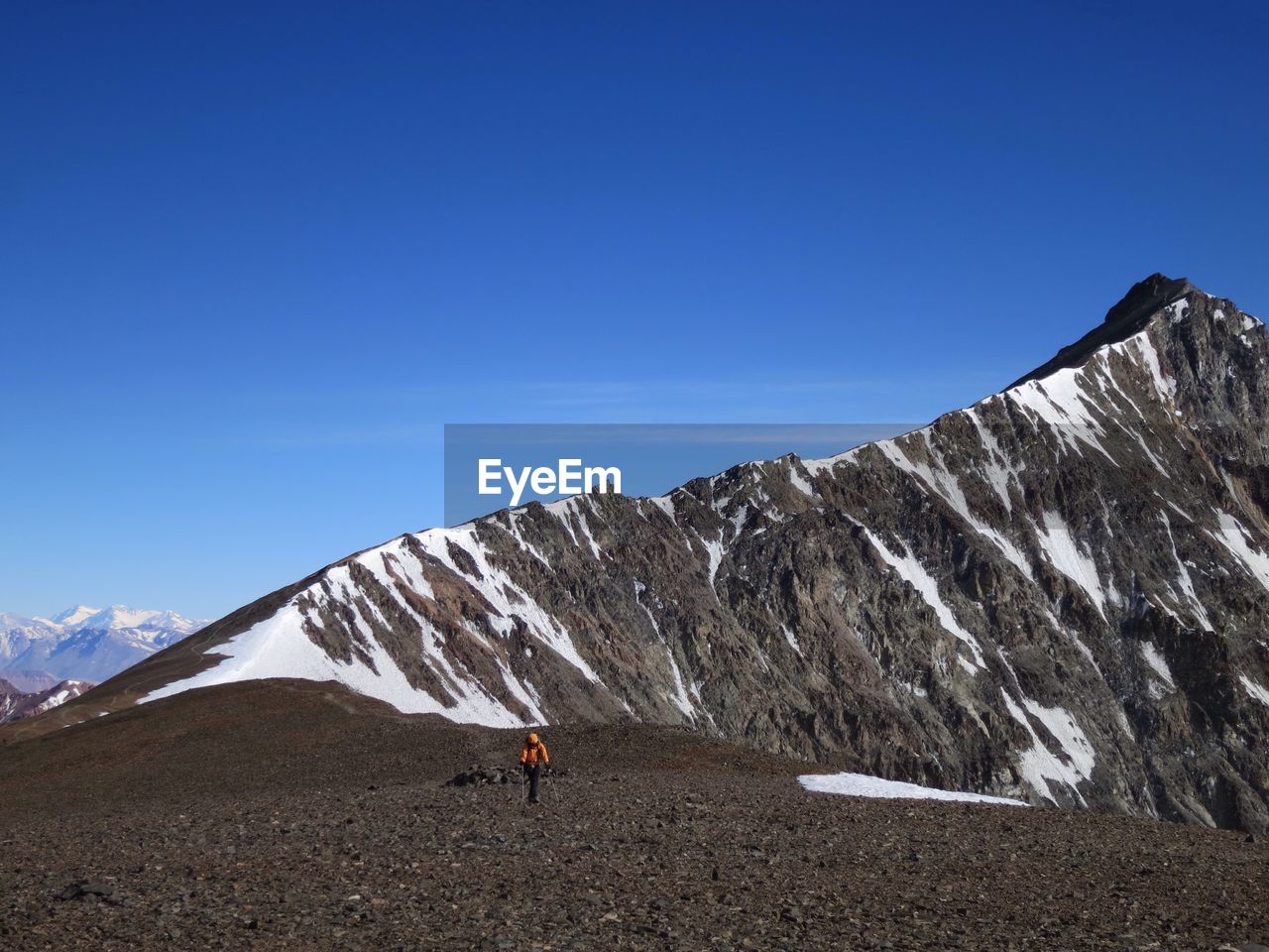 Rear view of person on snowcapped mountains against blue sky
