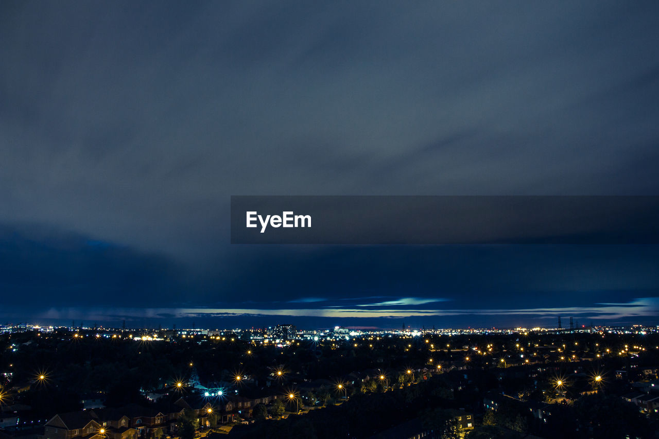 High angle view of illuminated cityscape against sky at night