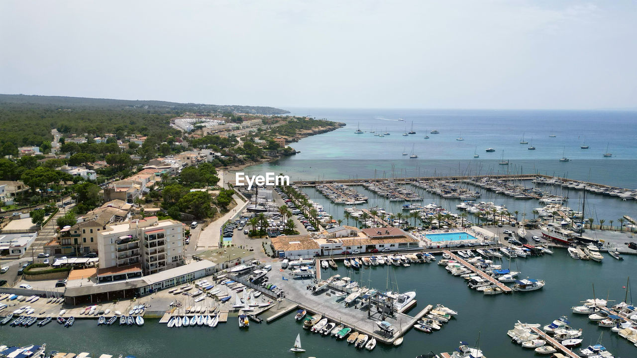 high angle view of buildings by sea against sky
