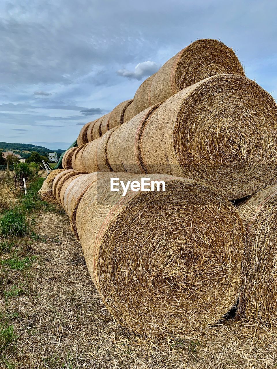 Hay bales on field against sky