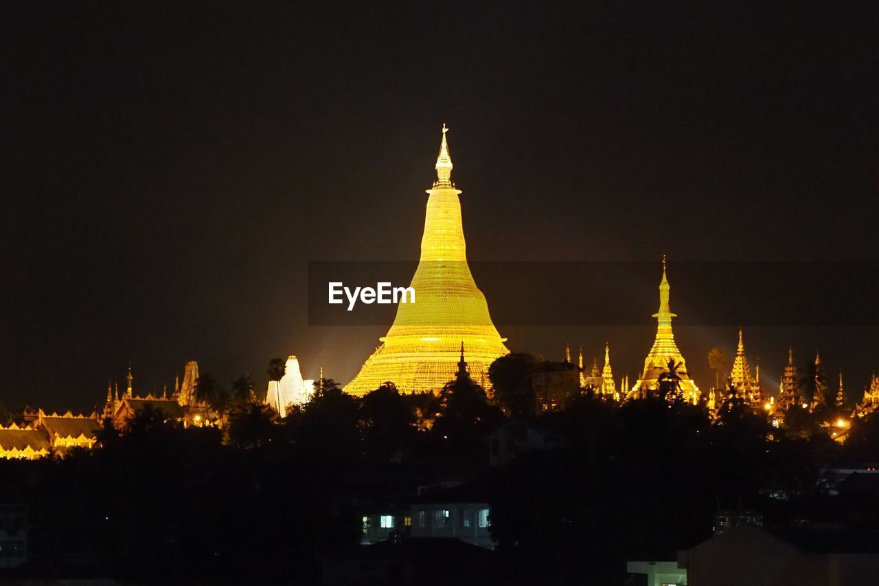 VIEW OF ILLUMINATED TEMPLE AGAINST SKY AT NIGHT