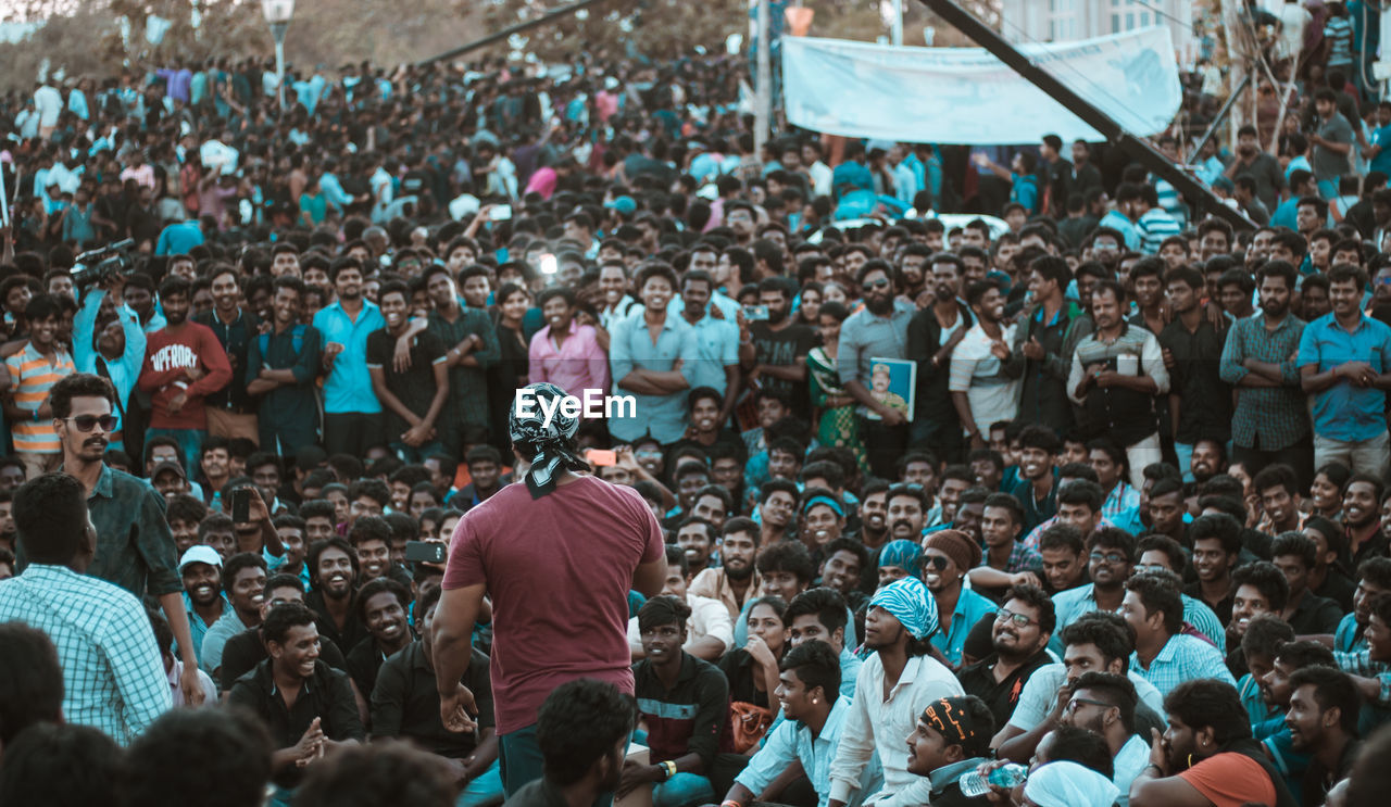 GROUP OF PEOPLE STANDING IN FRONT OF CROWD AT MARKET