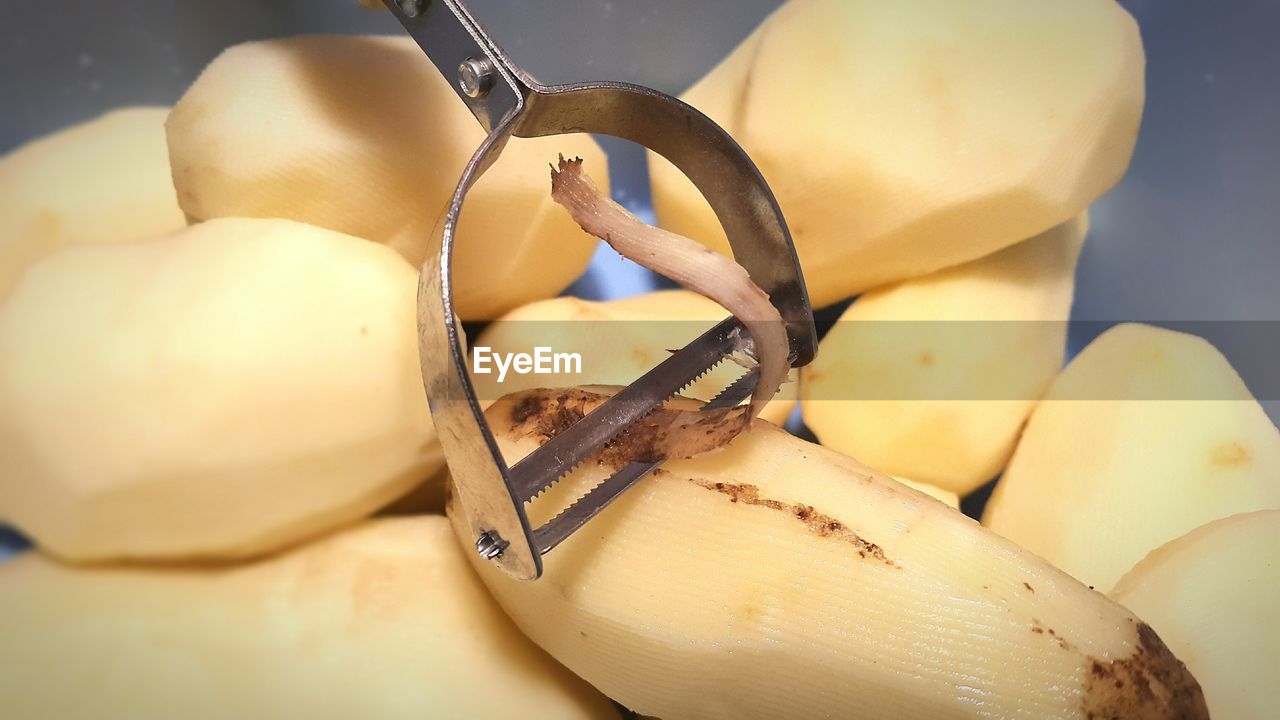 High angle view of potatoes and peeler