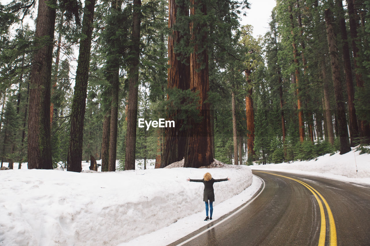 View of woman walking on snow covered road