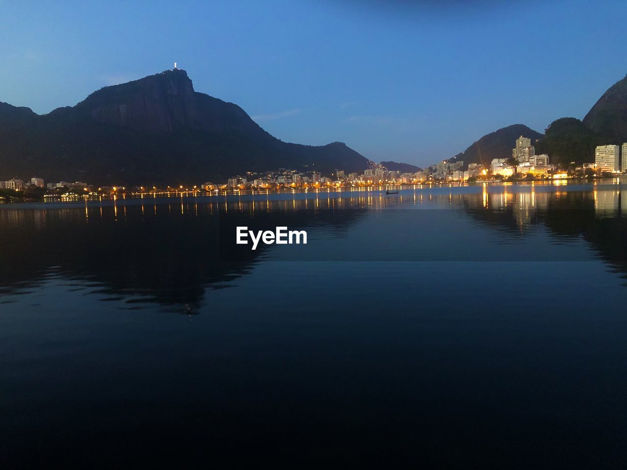 Scenic view of lake by mountains against clear sky