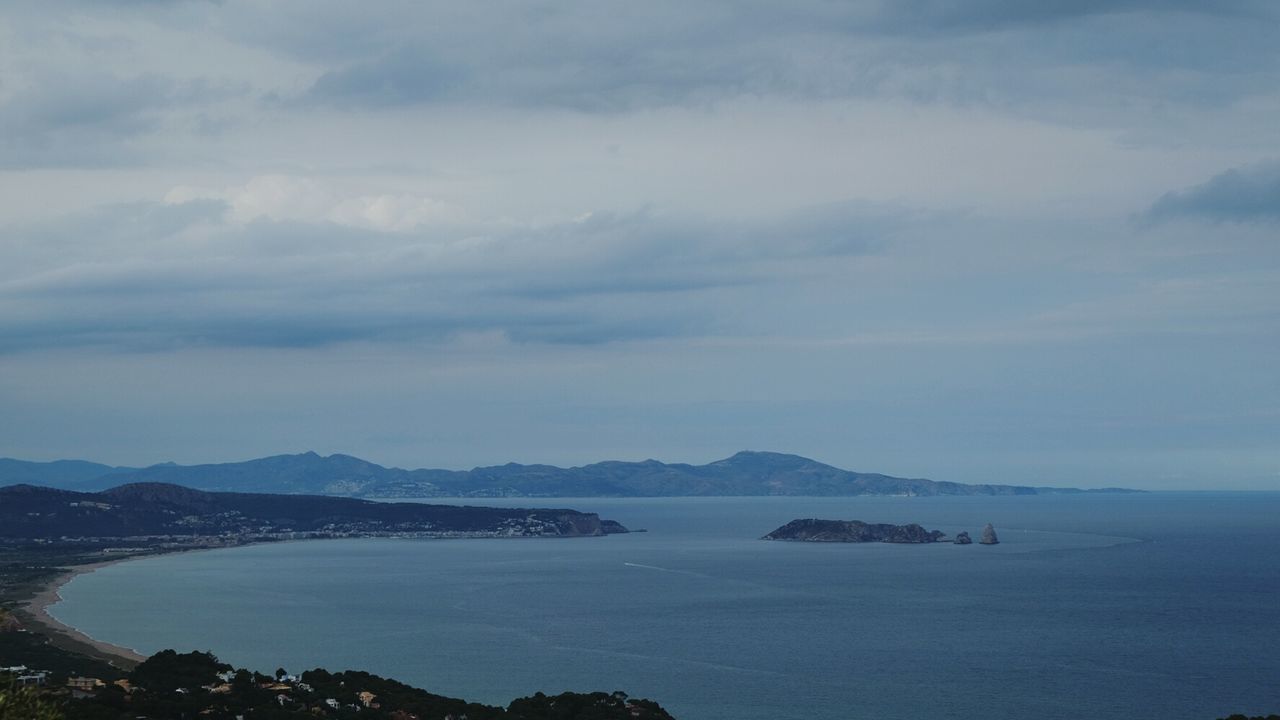 SCENIC VIEW OF SEA BY MOUNTAIN AGAINST SKY