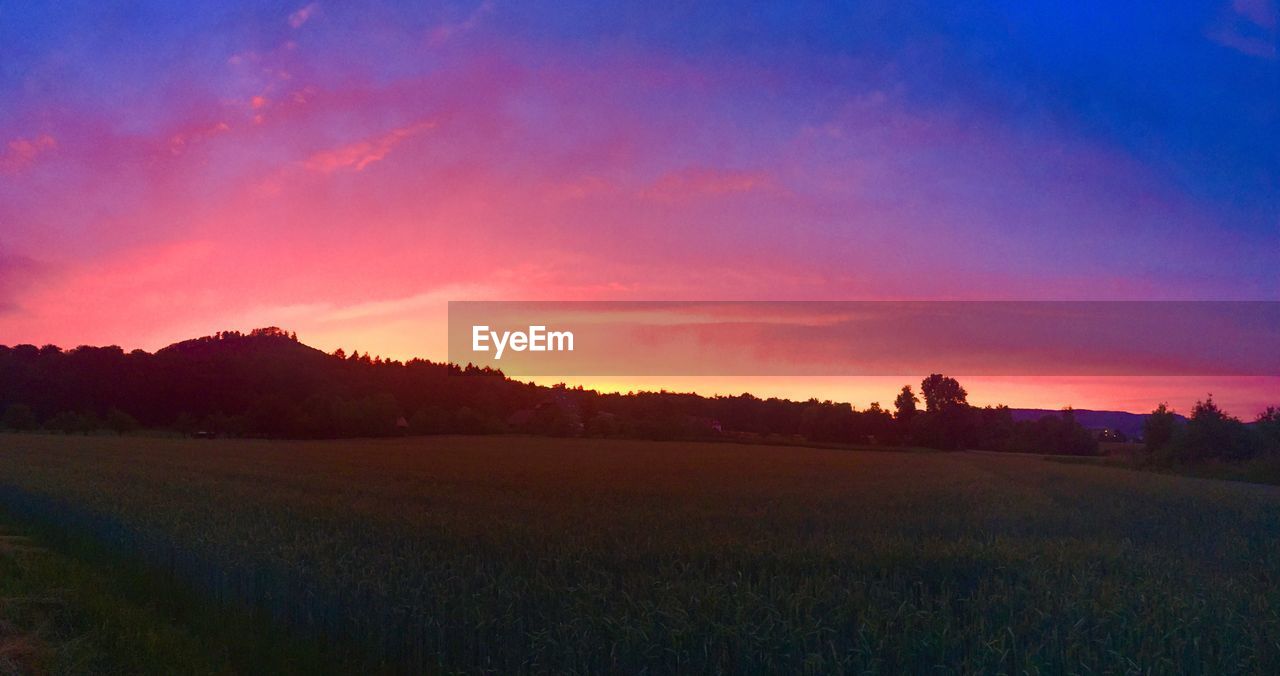 SCENIC VIEW OF AGRICULTURAL FIELD AGAINST SKY DURING SUNSET