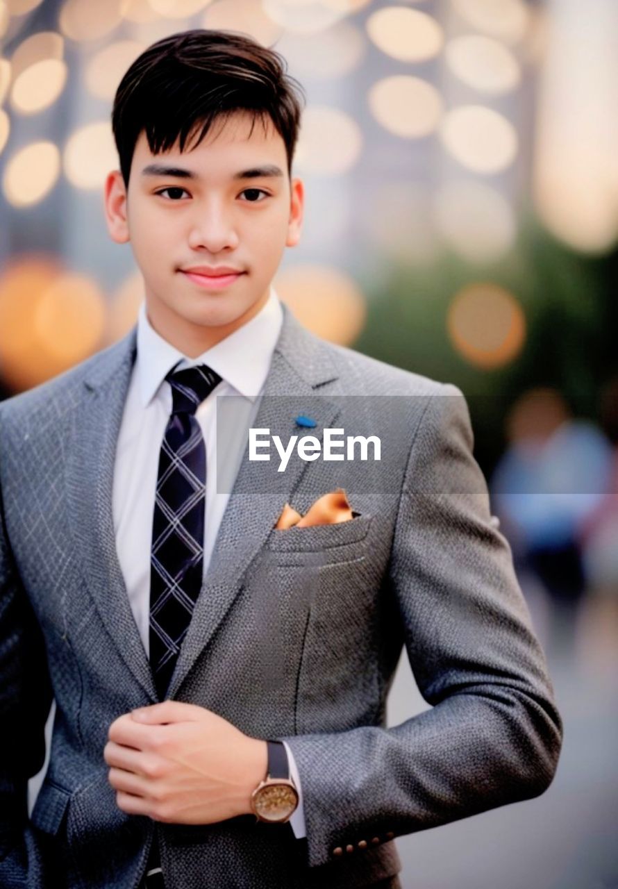 portrait of young man standing against defocused background