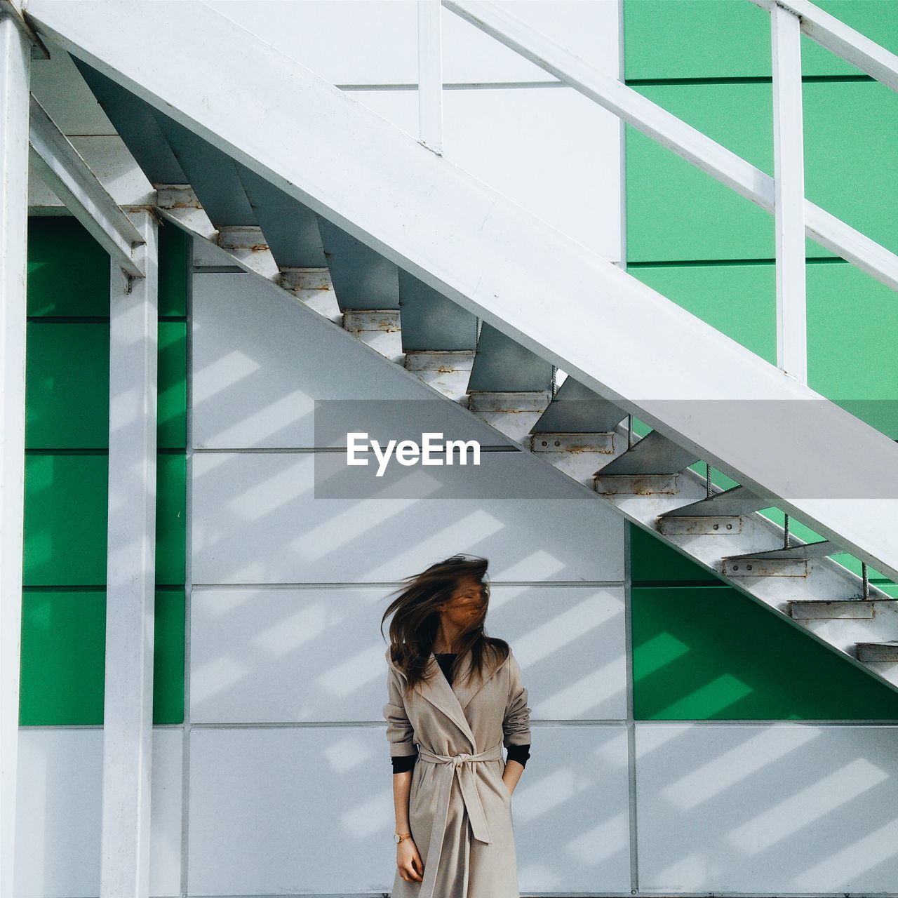 REAR VIEW OF YOUNG WOMAN ON STAIRCASE