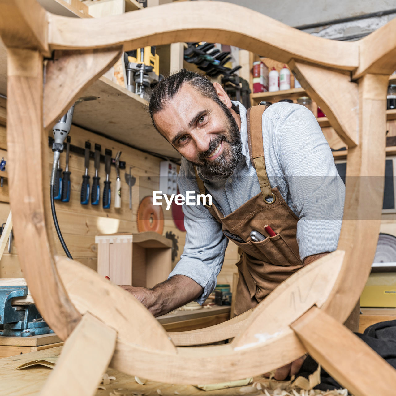 Portrait of carpenter working on wood in workshop