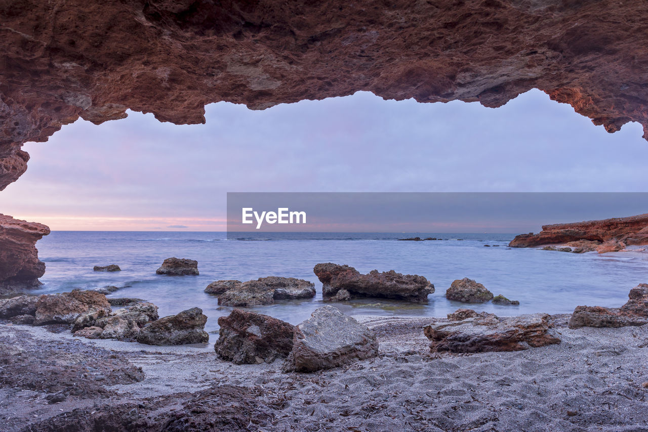 SCENIC VIEW OF ROCKS ON SEA AGAINST SKY