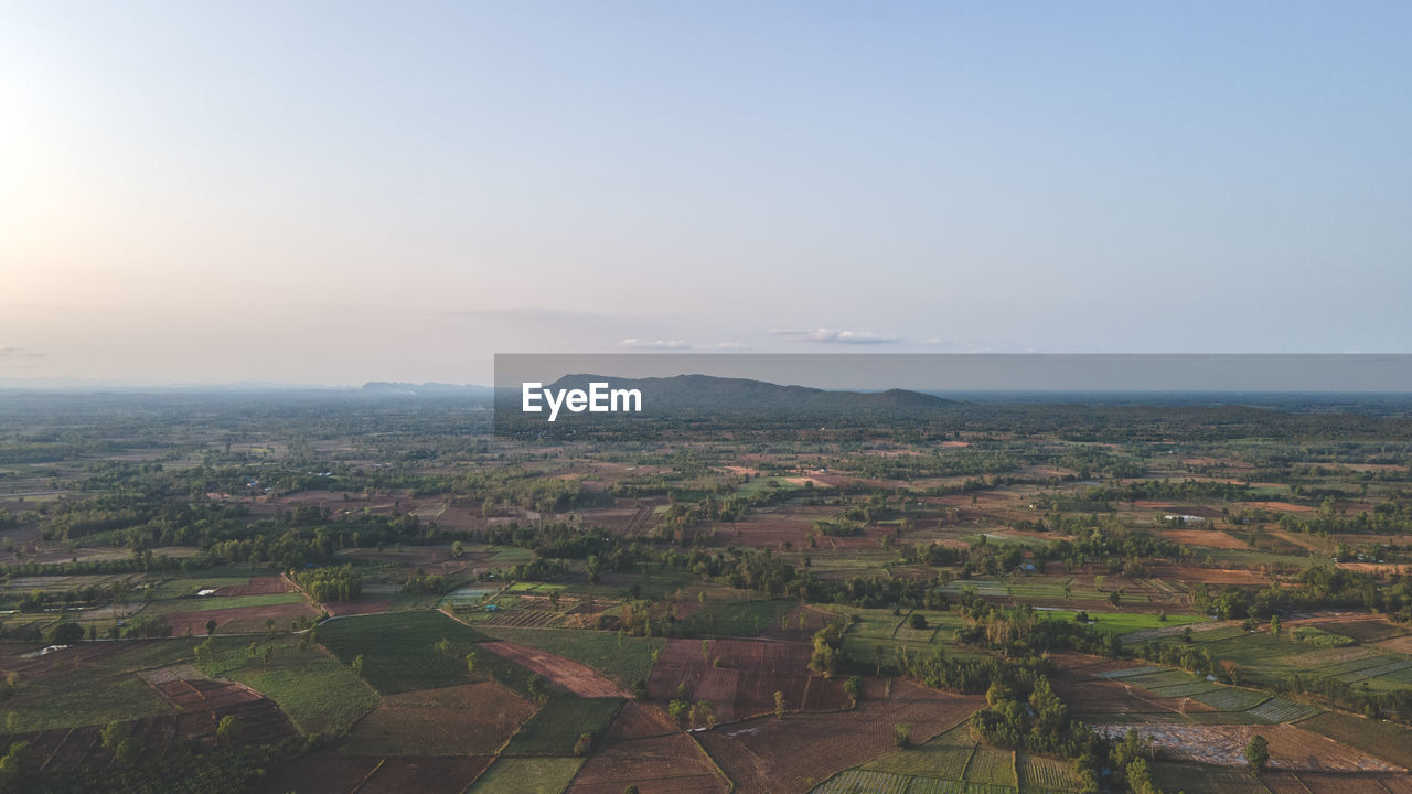 landscape, environment, sky, horizon, scenics - nature, nature, hill, aerial photography, land, rural scene, field, beauty in nature, architecture, agriculture, aerial view, city, tranquility, no people, building, high angle view, outdoors, tranquil scene, plain, sun, building exterior, travel, farm, sunlight, plant, blue, built structure, cloud, morning, day, idyllic, tree, fog, residential district, travel destinations, copy space, rural area, growth, horizon over land, sunny, urban skyline, tourism, social issues, bird's-eye view, cityscape, sunrise