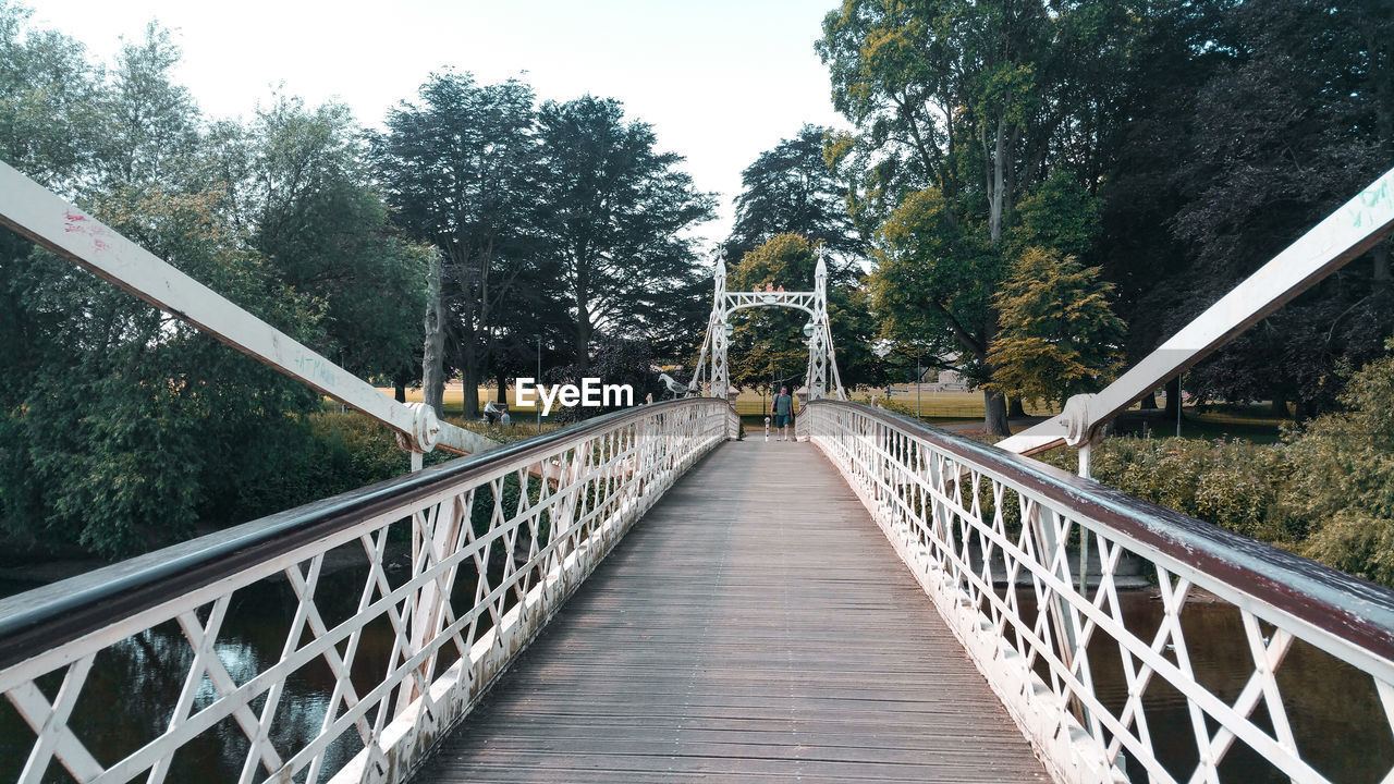 VIEW OF FOOTBRIDGE ALONG TREES