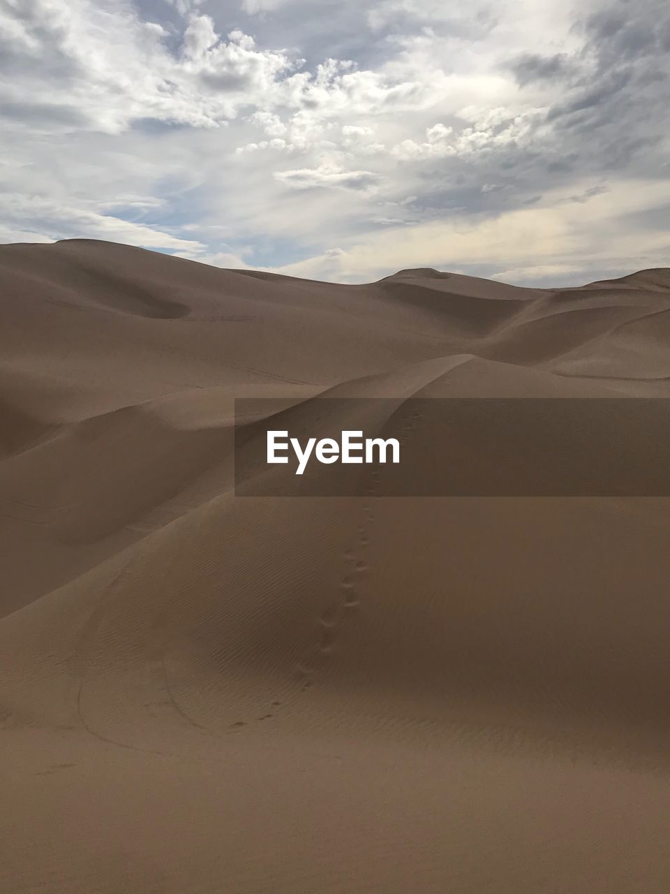 Sand dunes in desert against sky