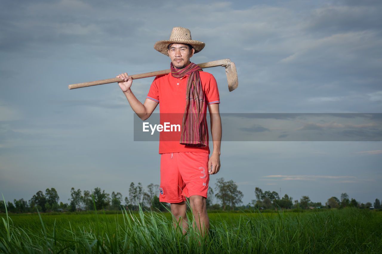 FULL LENGTH OF PERSON STANDING ON FIELD AGAINST SKY