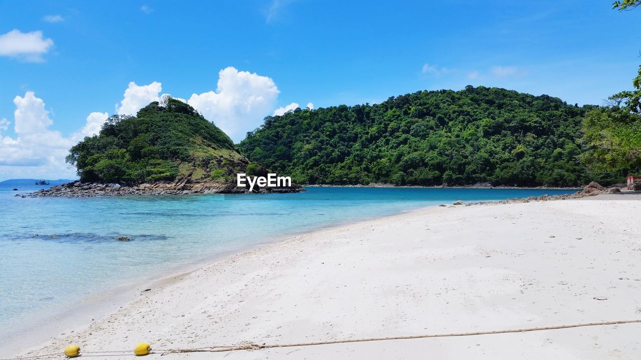 Scenic view of beach against blue sky