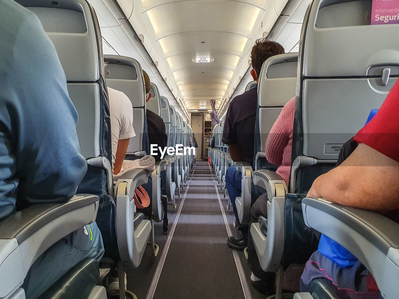 Cabin of airplane with passengers on seats waiting to take off