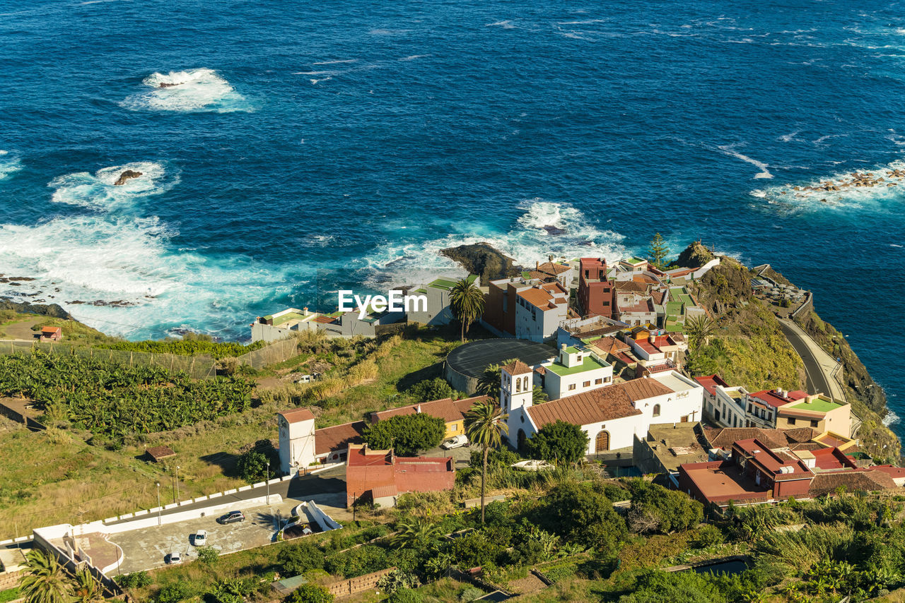 Farm village by the coast of tenerife with turquoise blue sea water