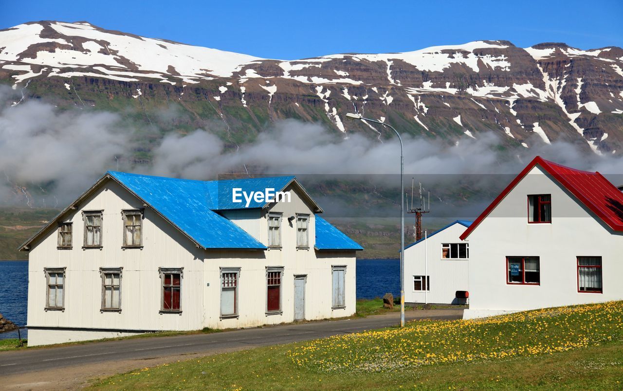 HOUSES ON MOUNTAIN AGAINST BLUE SKY