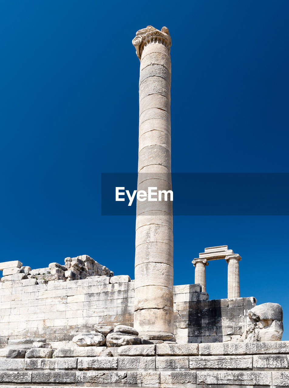 Low angle view of old ruins against clear blue sky