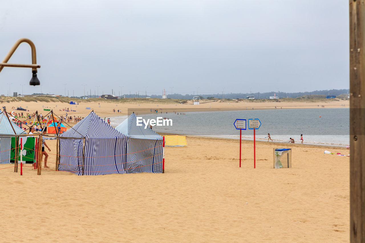 Deck chairs on beach against sky