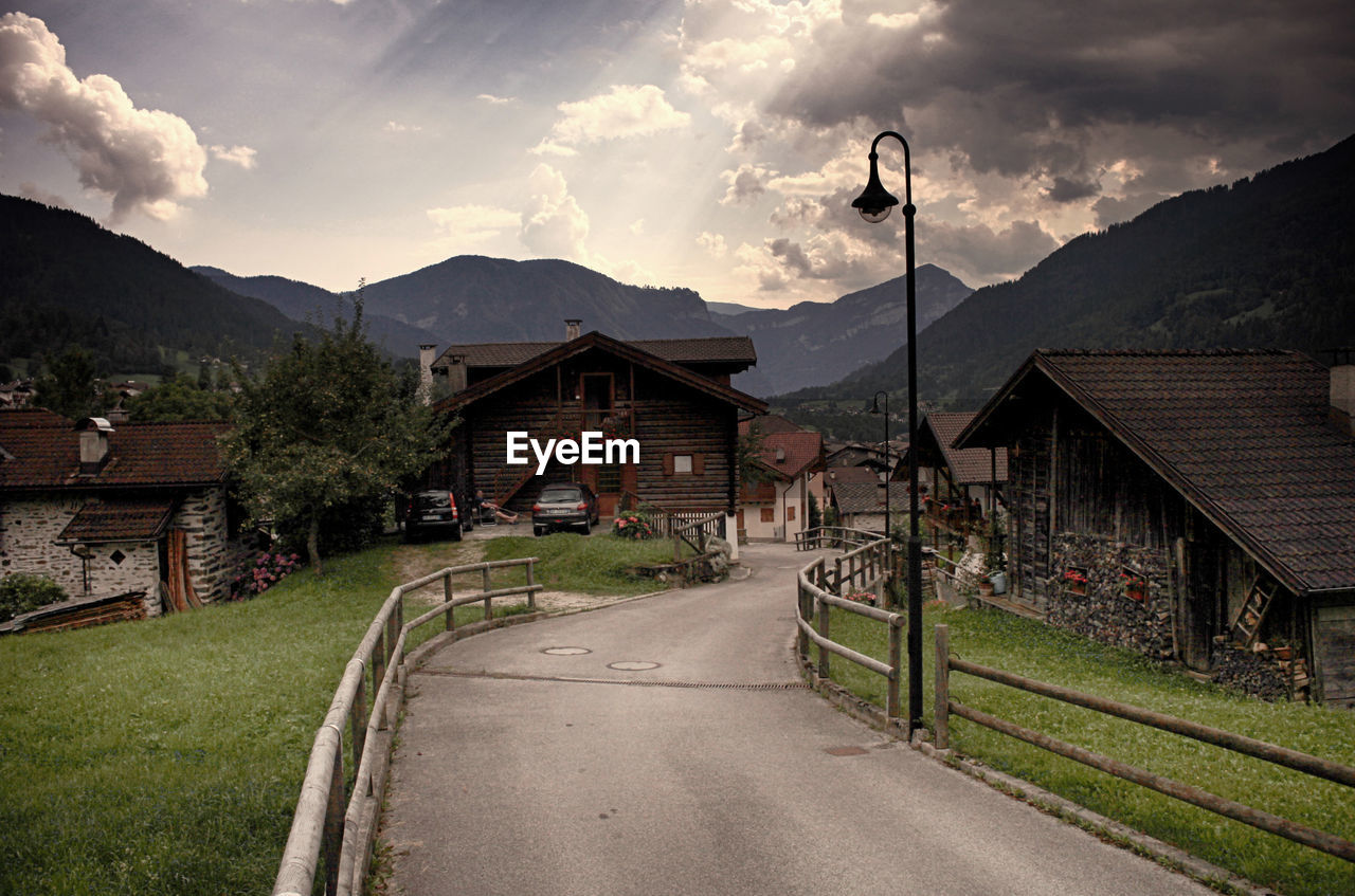 HOUSES BY ROAD AGAINST SKY IN CITY