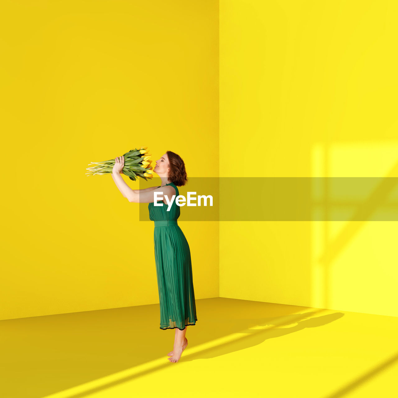 SIDE VIEW OF A WOMAN WITH YELLOW UMBRELLA