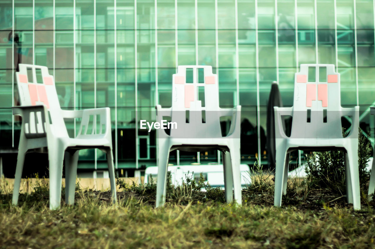 EMPTY CHAIRS IN FRONT OF BUILDING