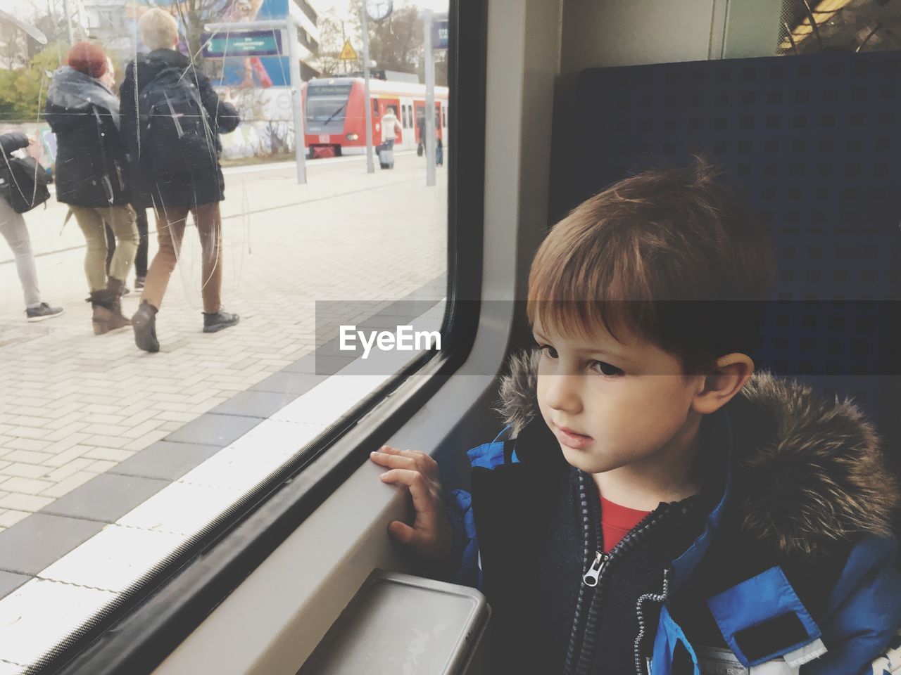 Cute boy looking away while sitting in train