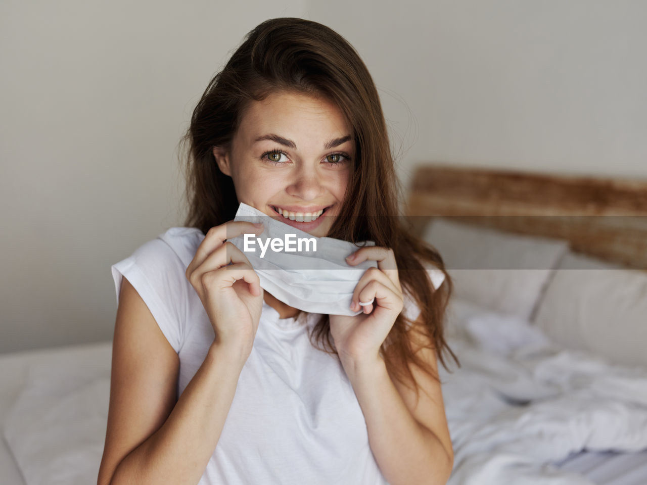 Portrait of smiling young woman relaxing on bed at home