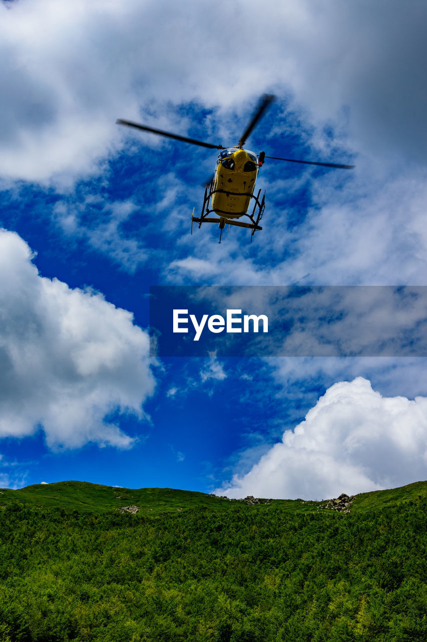 LOW ANGLE VIEW OF HELICOPTER AGAINST SKY