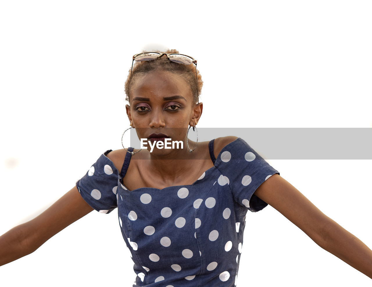 Portrait of young woman standing against white background