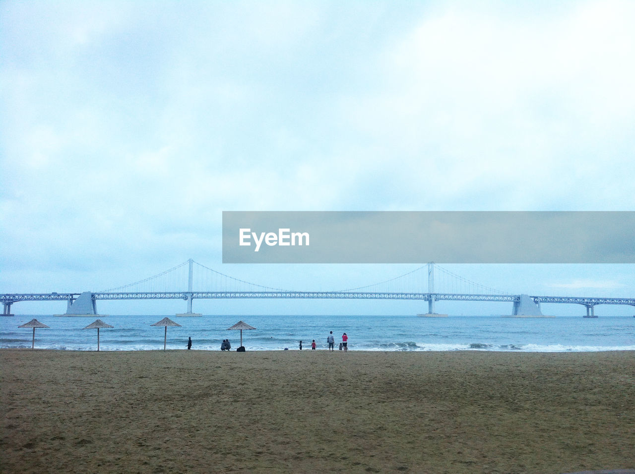 Gwangan bridge over sea against cloudy sky
