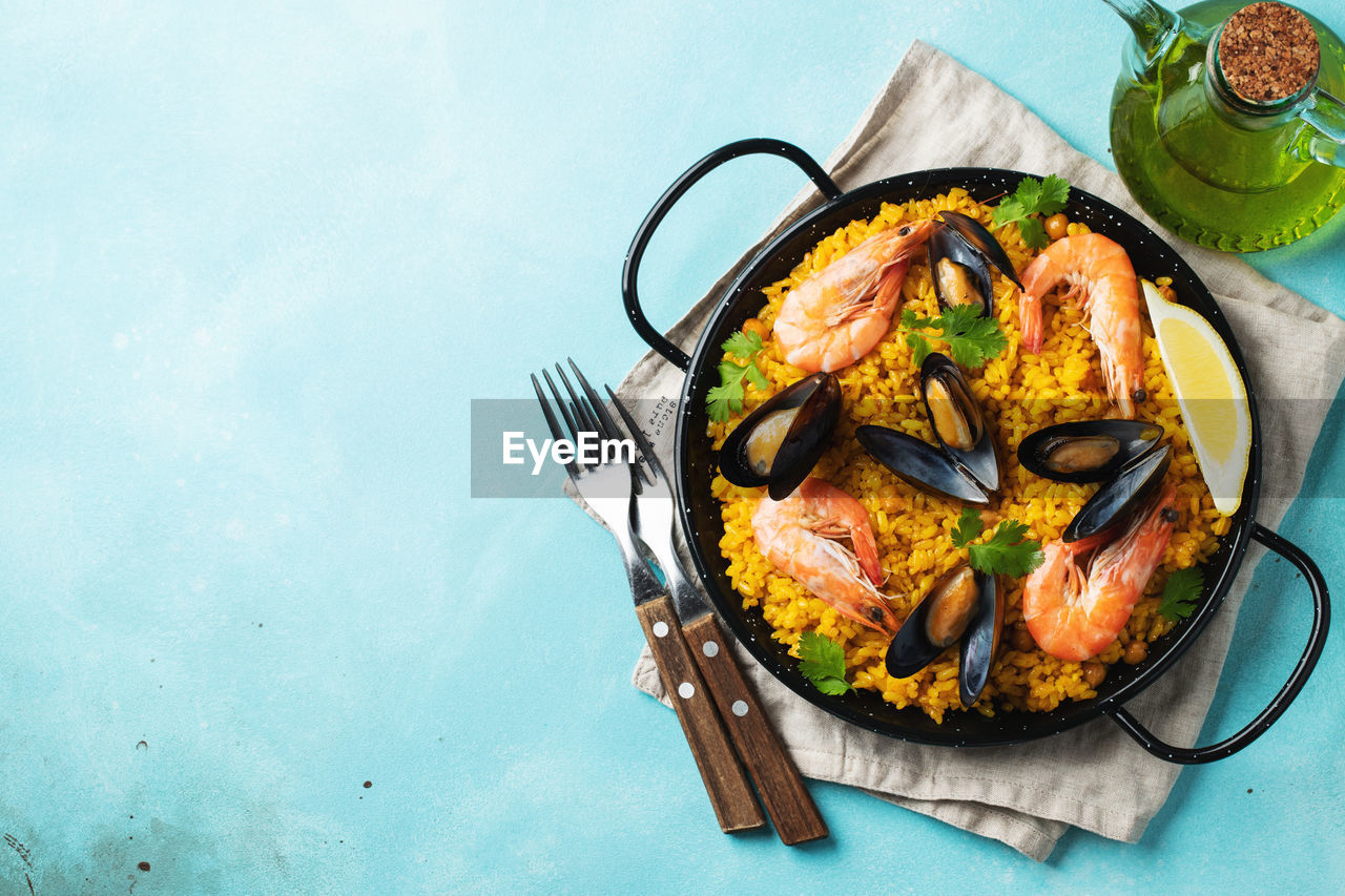Traditional spanish seafood paella in pan with chickpeas, shrimps, mussels, squid.
