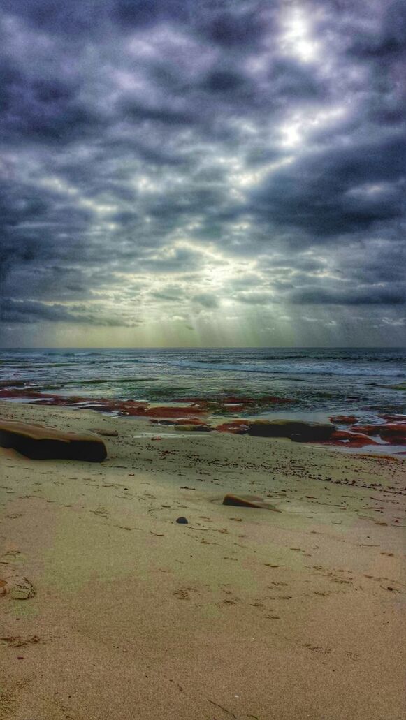 VIEW OF BEACH AGAINST CLOUDY SKY