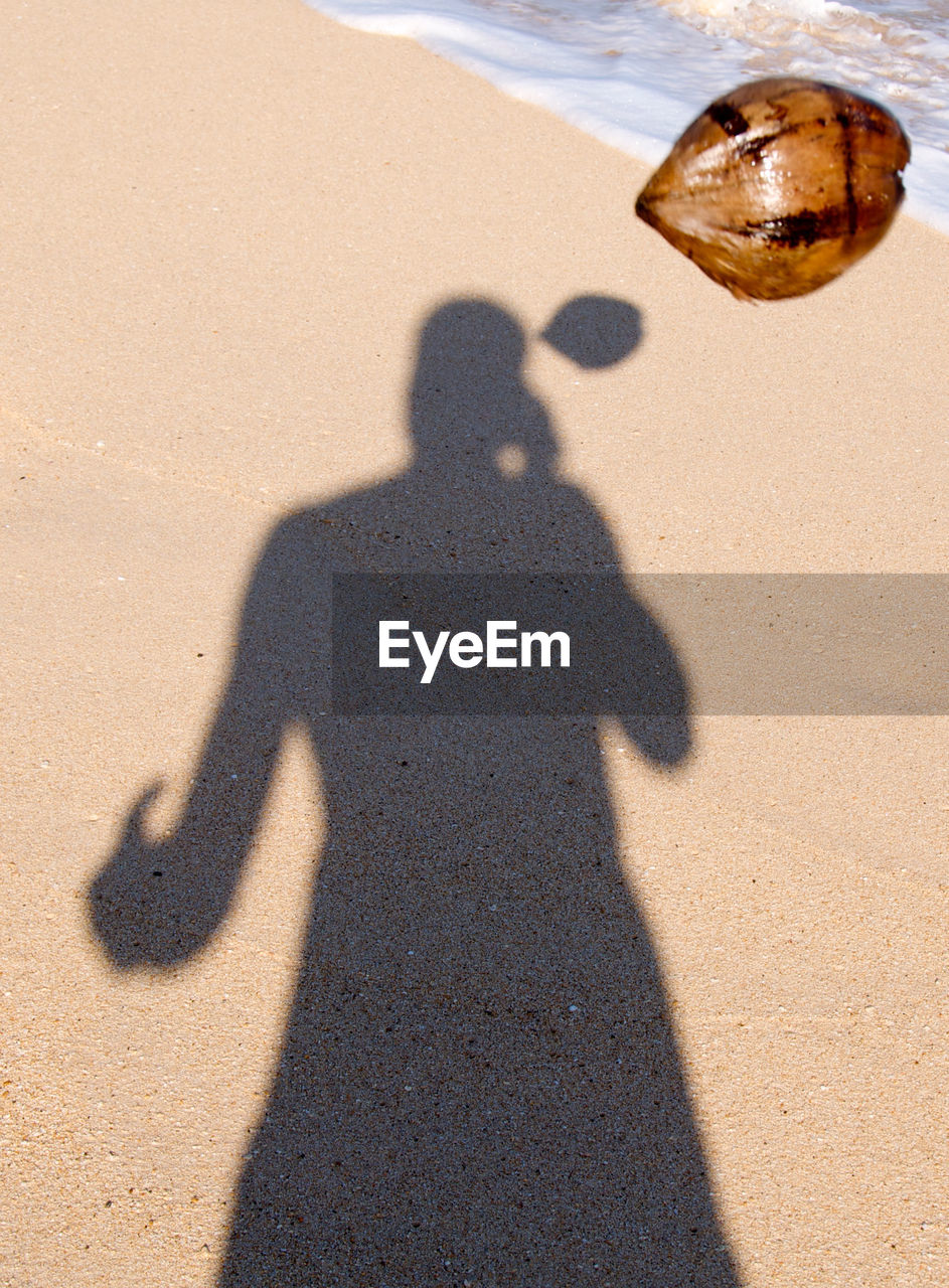 SHADOW OF PEOPLE ON SANDY BEACH