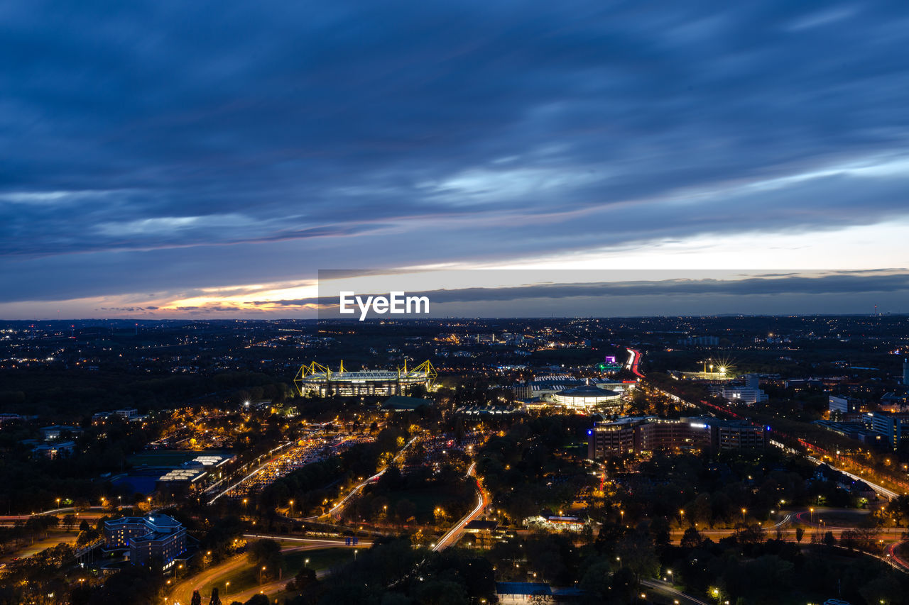 HIGH ANGLE VIEW OF ILLUMINATED CITY BUILDINGS AT NIGHT