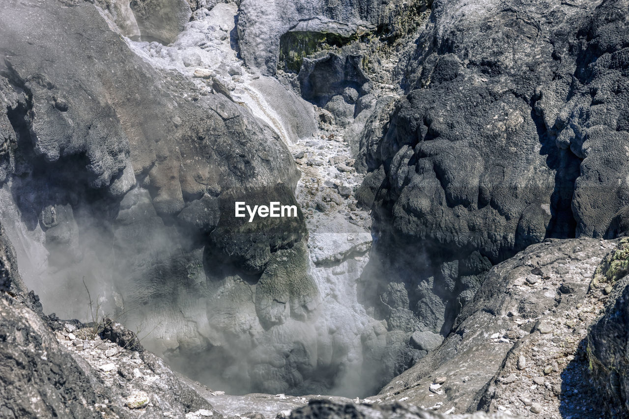 HIGH ANGLE VIEW OF WATER FLOWING OVER ROCKS