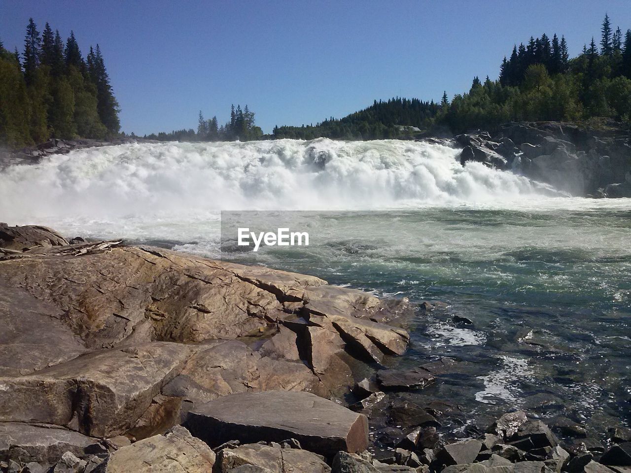 SCENIC VIEW OF WATERFALL AGAINST SKY