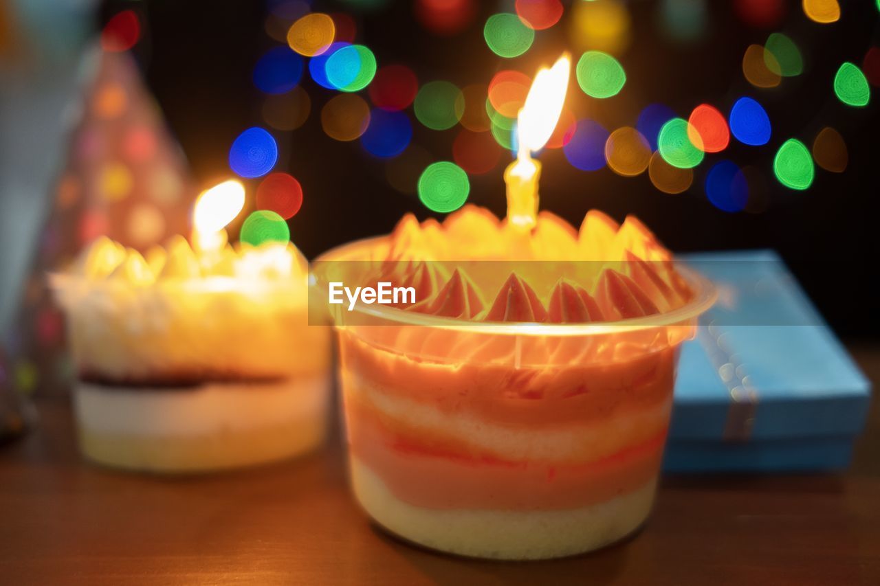 CLOSE-UP OF ILLUMINATED CAKE