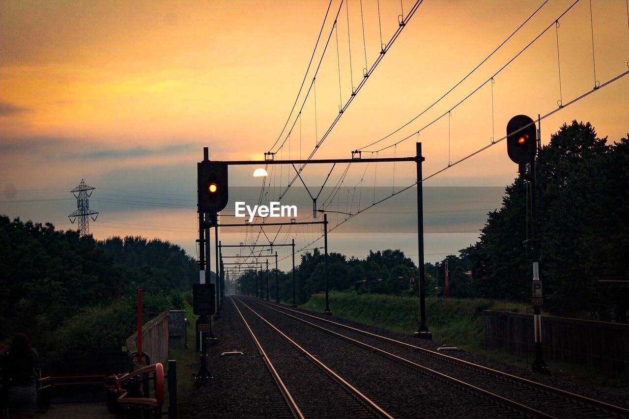 RAILROAD TRACKS AGAINST SKY DURING SUNSET