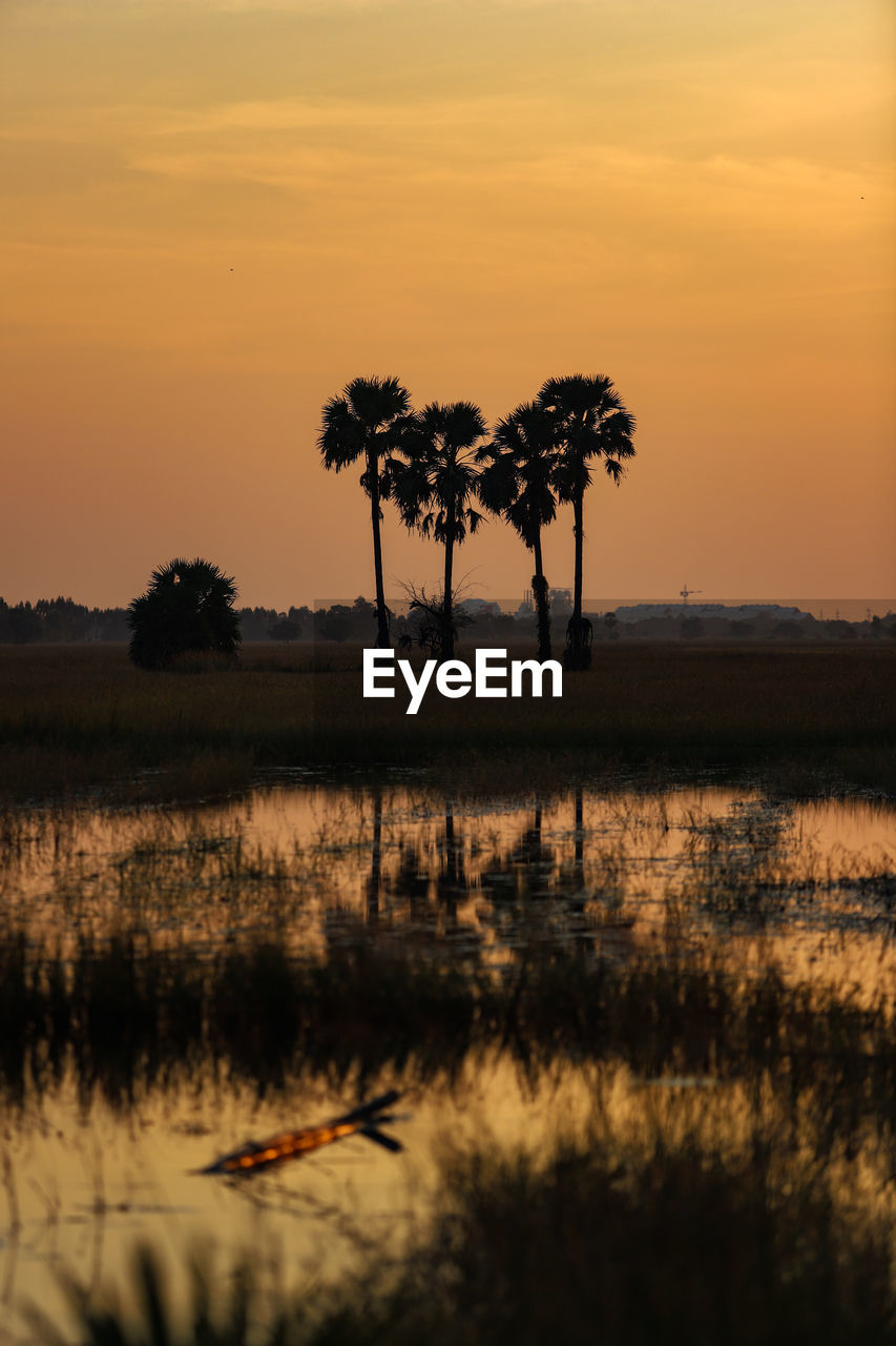 Scenic view of lake against orange sky