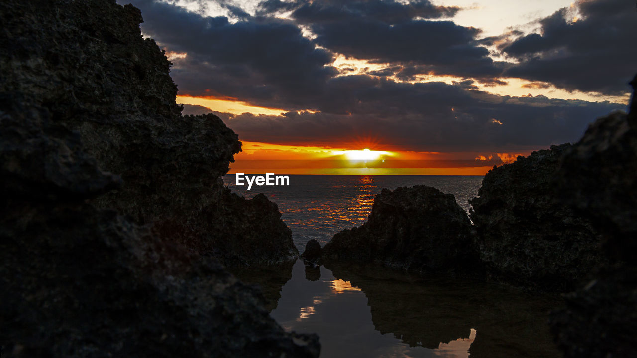 SCENIC VIEW OF ROCK FORMATIONS IN SEA AGAINST SKY