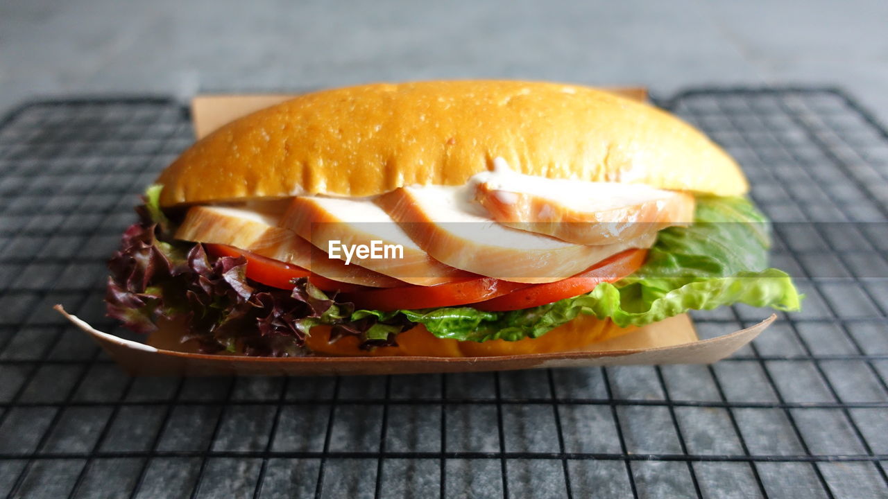 Close-up of roasted chicken sandwich bread, burger on table